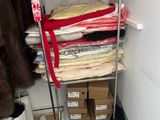 a closet with a shelf full of clothes and other items