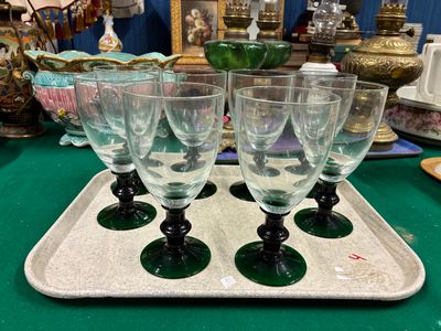 quatre verres à vin posés sur un plateau, sur une table