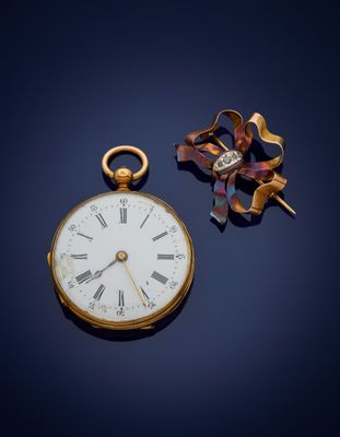 a gold pocket watch with roman numerals on it