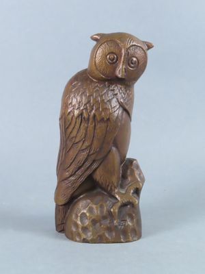 wooden owl figurine sitting on top of a tree stump