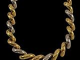un collier en or et en argent sur fond noir