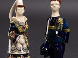 two figurines of a man and a woman standing next to each other