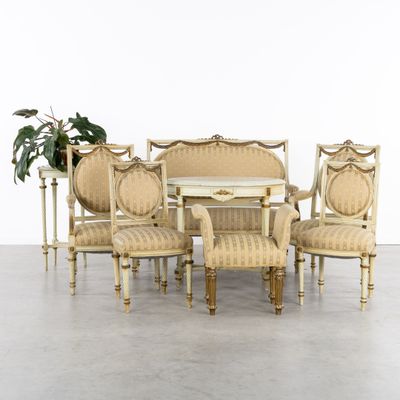 a table and six chairs in a room with a potted plant in the corner