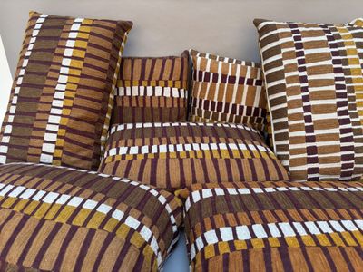 de nombreux coussins disposés sur un canapé à motifs marron et blancs