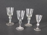 quatre verres à vin transparents posés sur une table noire