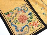 a close up of a yellow and black cloth with flowers on it
