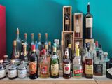 plusieurs bouteilles d'alcool posées sur une table devant un mur bleu