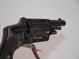 a small black gun with a red string attached to it