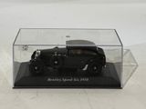 a black model of a car in a glass case