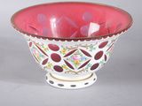 a red and white bowl sitting on a white table