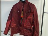 une veste rouge accrochée à un portant dans une pièce