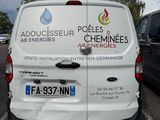 a white van parked in a parking lot next to a black car