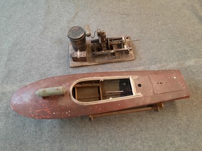 une petite maquette de bateau posée par terre à côté d'une autre petite maquette de bateau
