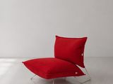 une chaise rouge placée dans une pièce blanche, près d'une fenêtre