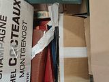 a box full of books sitting on the floor next to a pile of other books