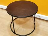 a black table with a brown top on a wooden floor