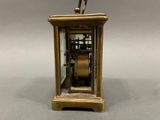 a gold clock with a bird on top of it