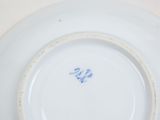 a white plate with blue writing on it on a table