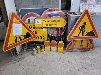 many construction signs on the ground next to a building