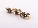 a close up of a gold and black broochle broochle on a white surface