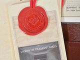 un cachet de cire rouge fixé à un portefeuille marron