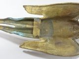 brass figurine of a fish with a long tail on a white surface