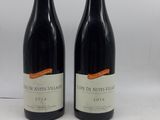 deux bouteilles de vin rouge posées sur une table blanche