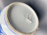 a close up of a blue and white vase with a tag on it