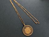 un collier en or orné d'une pièce, posé sur une table