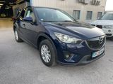 La Mazda CX-5 bleue est garée devant un immeuble