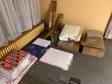 beaucoup de cartons par terre, à côté d'un lit