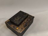 an old black box sitting on top of a white surface