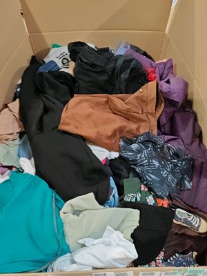 a cardboard box filled with clothes and other items