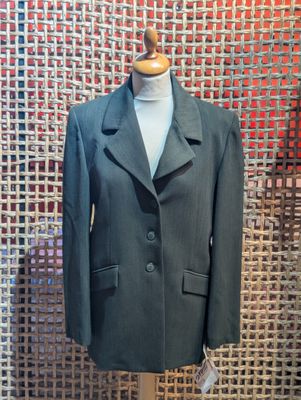 a suit on a mannequin stand in front of a wall