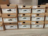 boxes of shoes are stacked on top of each other on the floor