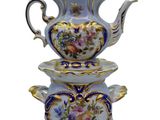 a blue and white tea pot and saucer on top of each other