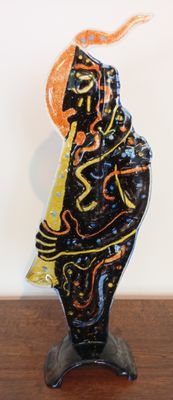a glass sculpture of a woman standing on a wooden table