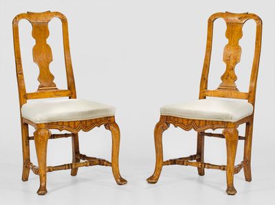 deux chaises en bois avec des assises rembourrées et un coussin blanc