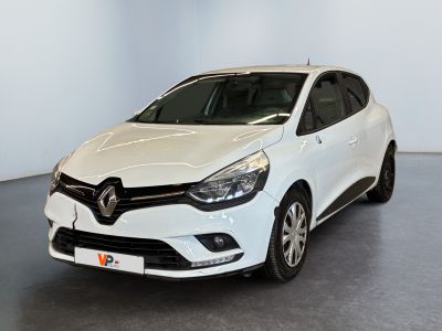 La voiture blanche est garée dans une grande pièce au sol noir.