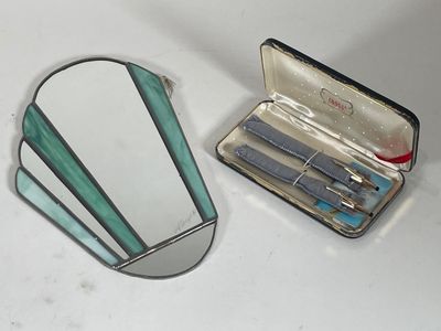 un miroir, des ciseaux et un étui posés sur une table