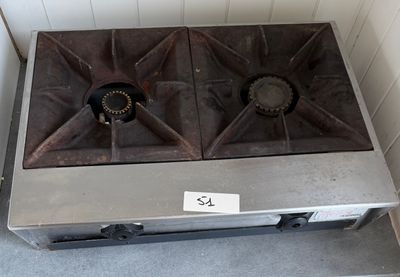 une plaque de cuisson en métal à deux feux, sur laquelle est apposée une étiquette