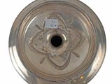 a silver plate on a white background with a tag on it