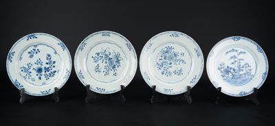 quatre assiettes bleues et blanches ornées de fleurs sur fond noir