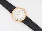 a close up of a watch on a white surface with a black strap