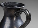 a black vase that has a handle on it