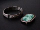 pair of silver and jade bracelets on a black surface