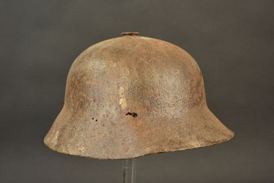 an old helmet on a metal stand against a gray background