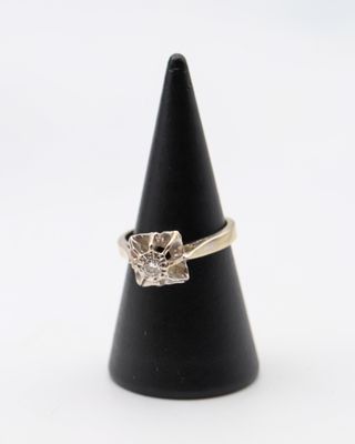 un gros plan d'une bague en diamant posée sur un cône noir