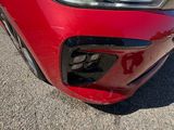 a close up of a red car ' s headlight and front bumper