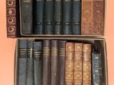 an open cardboard box filled with old books sitting on top of a pink surface
